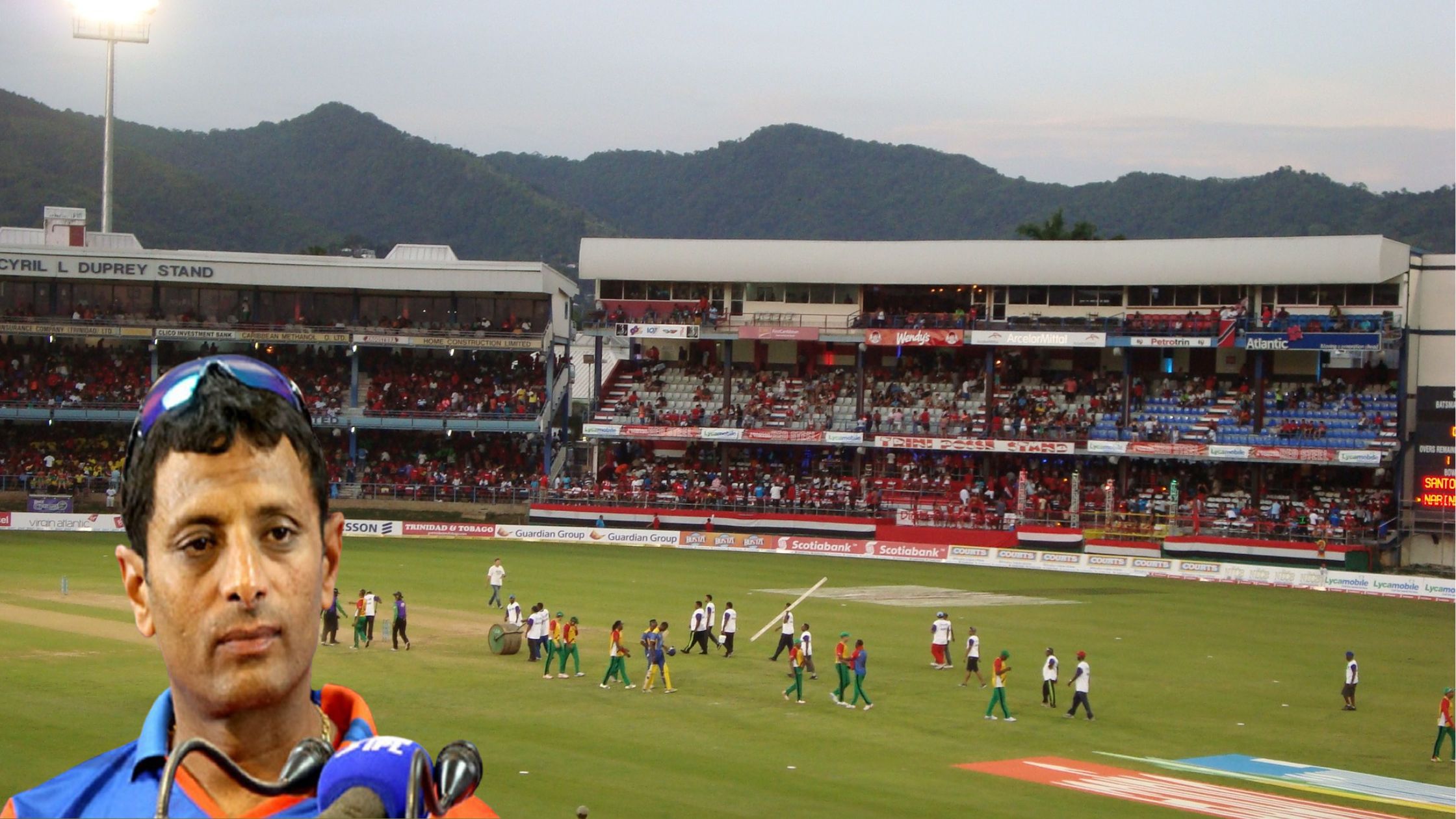 Sitanshu Kotak, the renowned cricketer, standing confidently in a bustling cricket stadium.