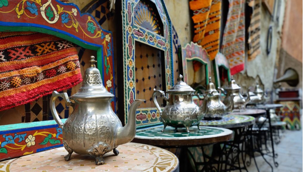 Traditional Moroccan tea kettle and tea set, symbolizing Moroccan culture and hospitality.

