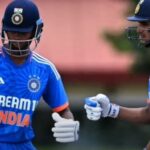 Cricketers Yashasvi Jaiswal and Shubman Gill shaking hands on the cricket field.